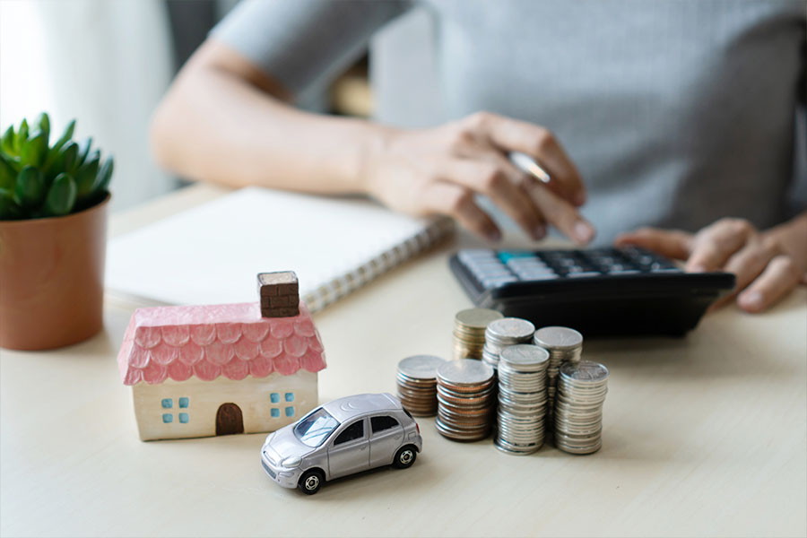 Home and Auto Insurance (Bundled) - Picture of a Woman's Hands with a House and Car on the Desk