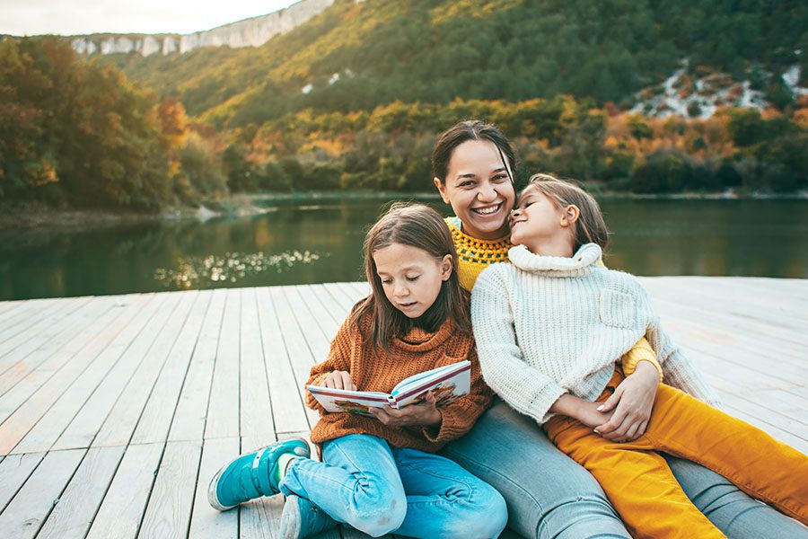 Blog - Mother and Young Daughters Spending Time Together on a Dock by the Lake