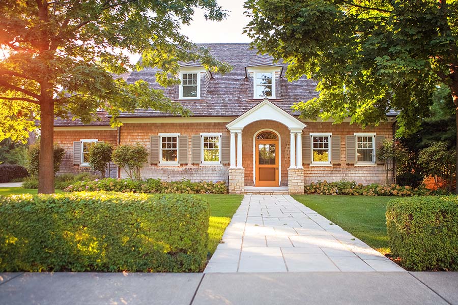 Home Insurance Local Pages - Traditional Style Brick House with Two Stories With Trees in the Front Yard During Sunrise