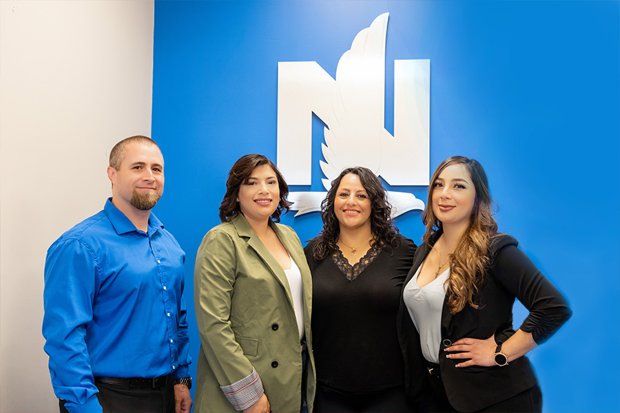 Yakima, WA Insurance - Empire Insurance Brokers Team Standing in Front of Nationwide Logo While Posing for a Photo